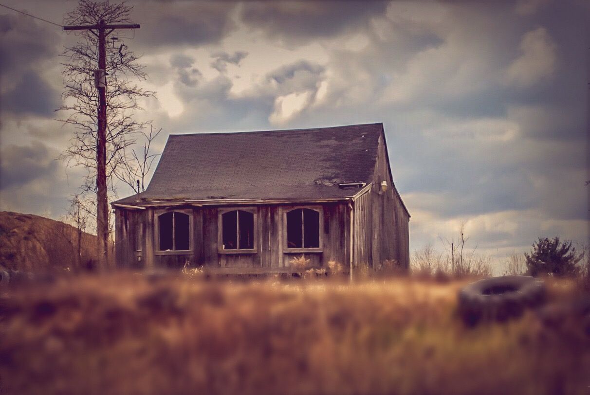 Run down house with tire in yard.